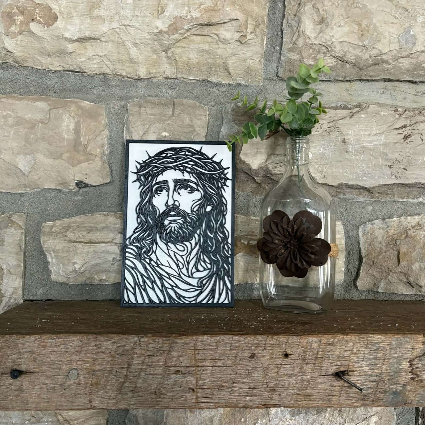 Layered wall art of Jesus with the crown of thorns sitting on a mantle