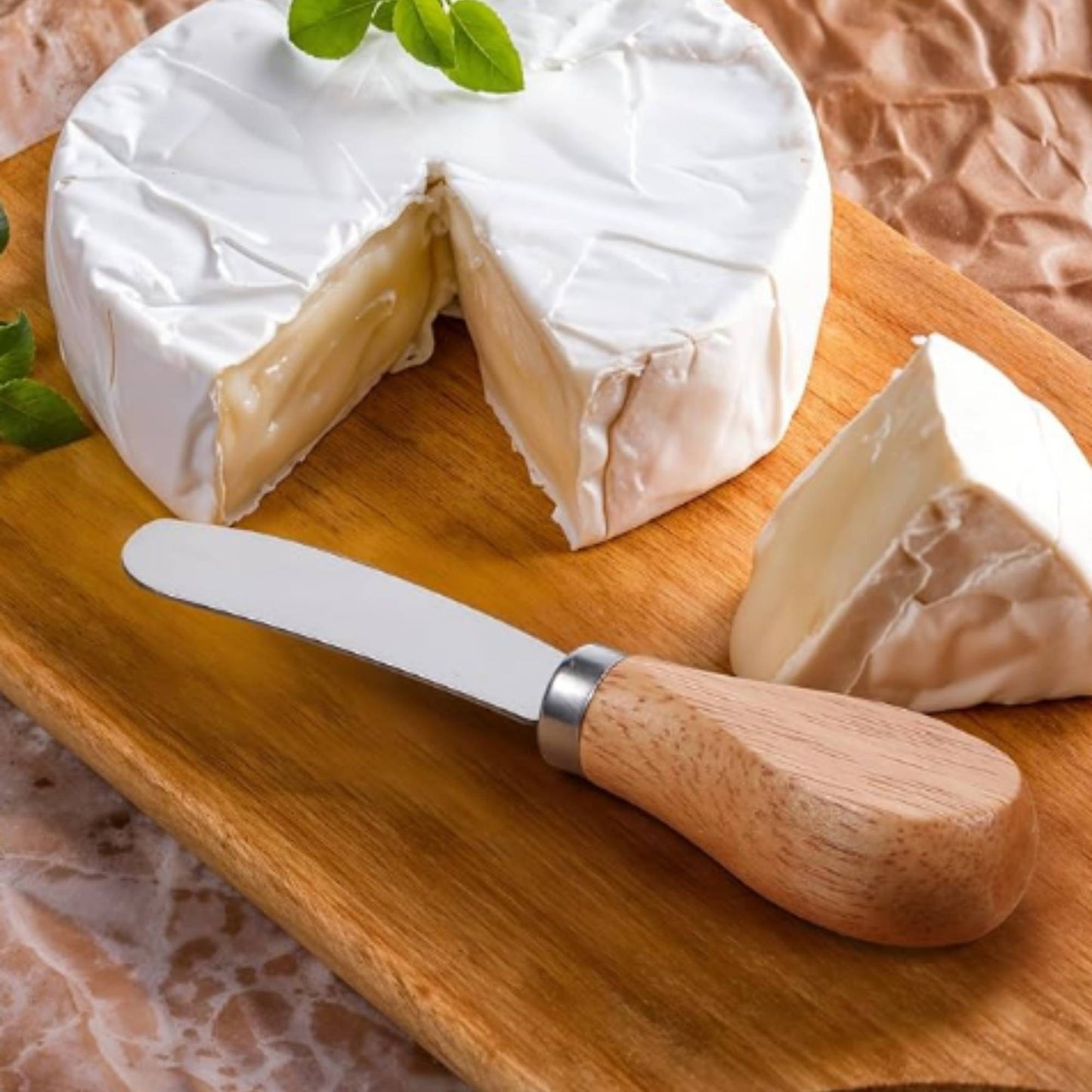 charcuterie knife sitting on serving board with brie cheese