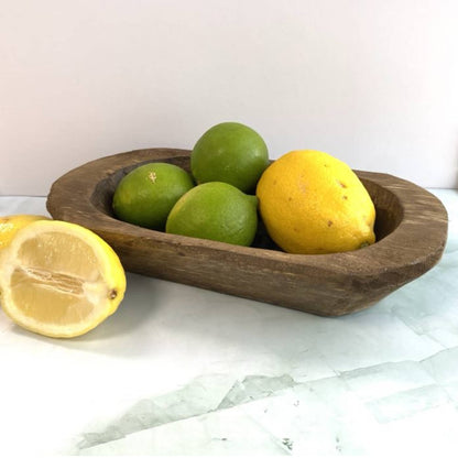 hand carved wood bowl with fruit in it on the counter