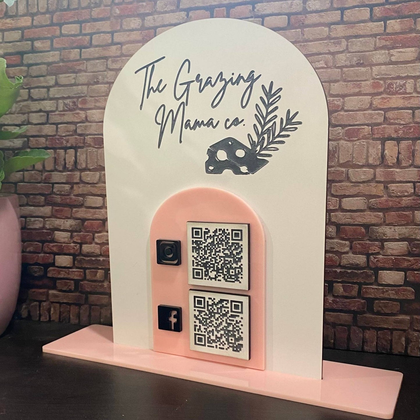 two piece acrylic business sign with QR codes and logos on shelf