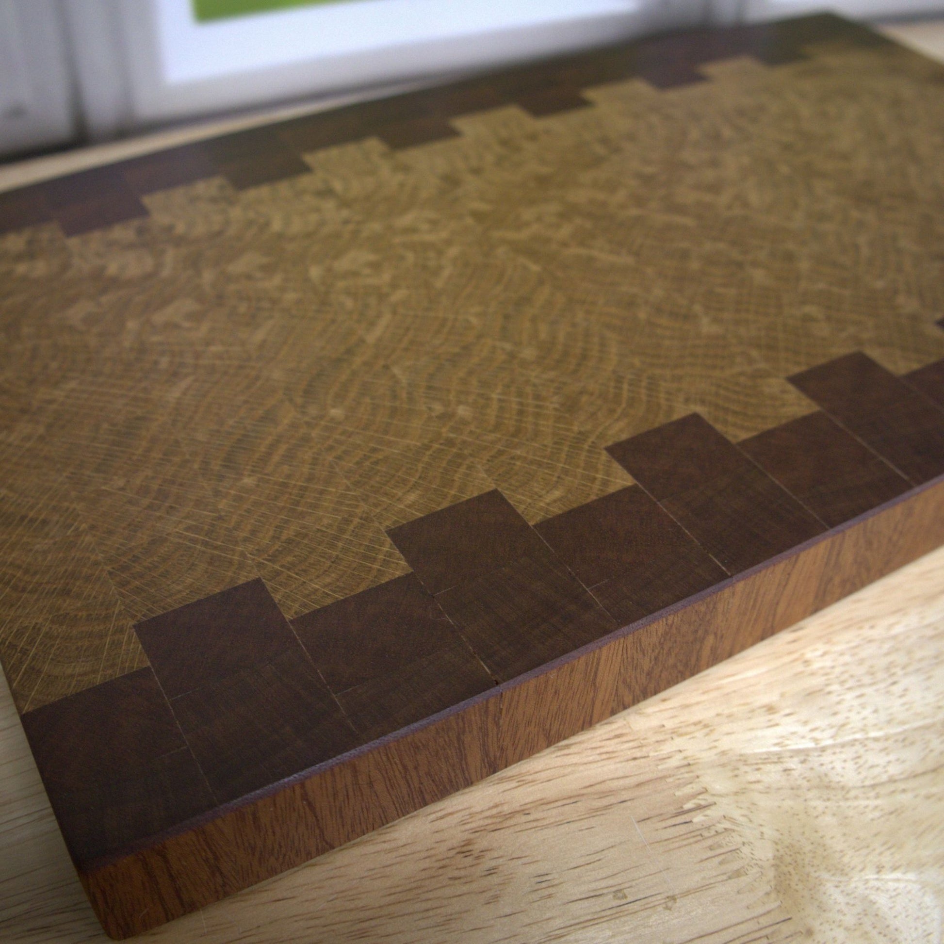 close up view of the grain of the Sapele and White Oak handcrafted end grain cutting board