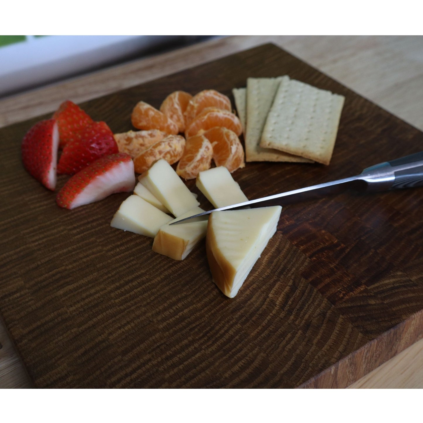 Handcrafted white oak end grain cutting board with fruits, cheese, and crackers