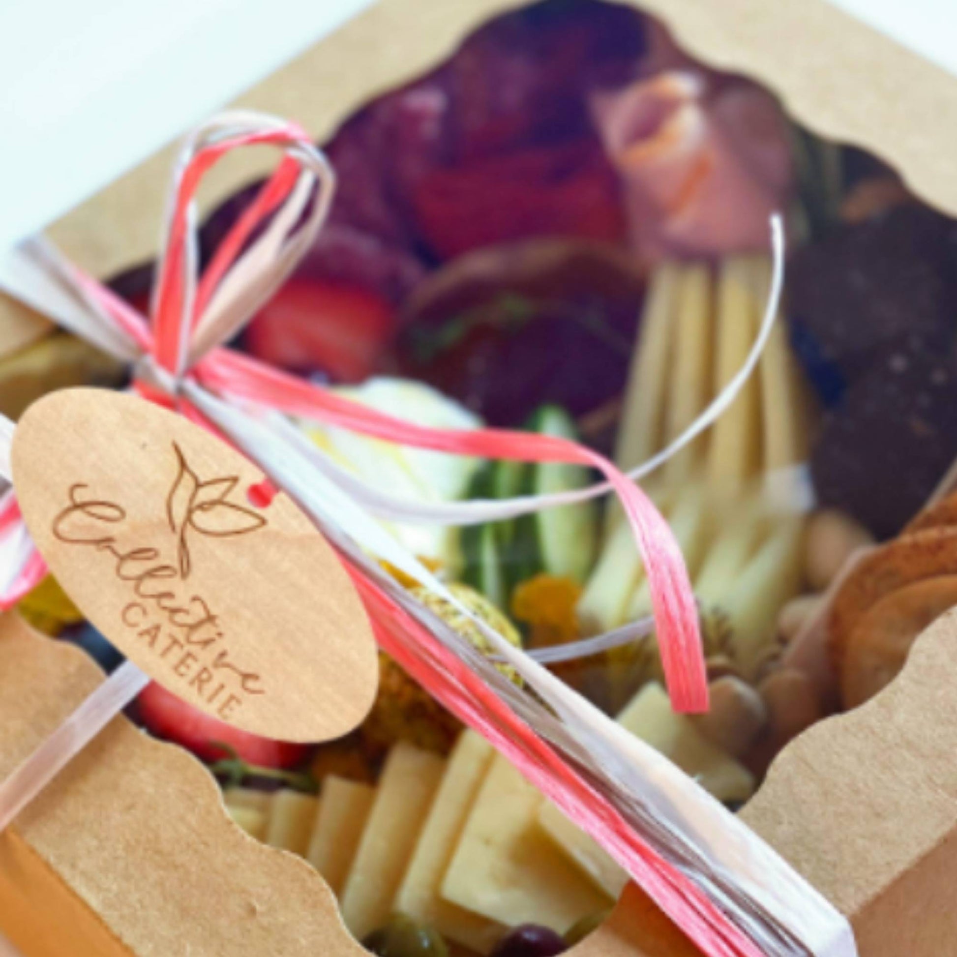 oval wood custom charcuterie box tag tied to a charcuterie box