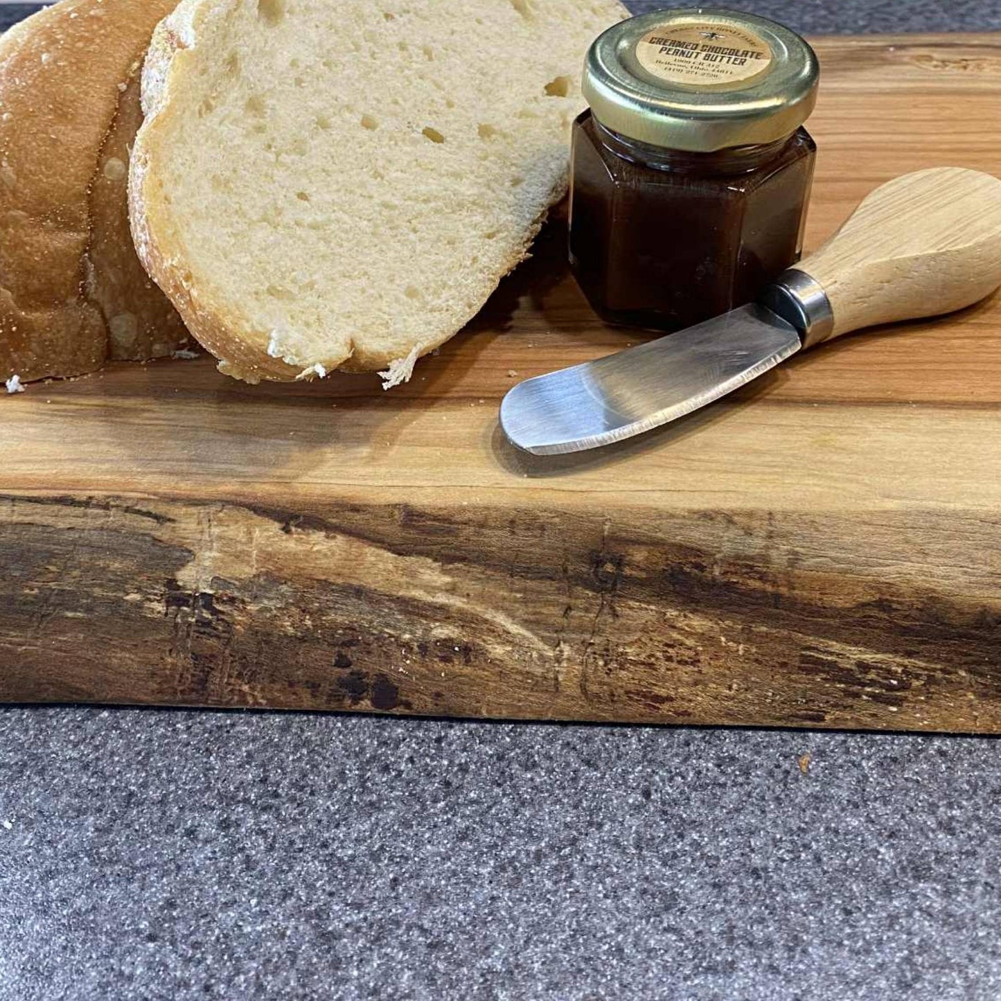 close up of live edge cherry board with bread and honey 