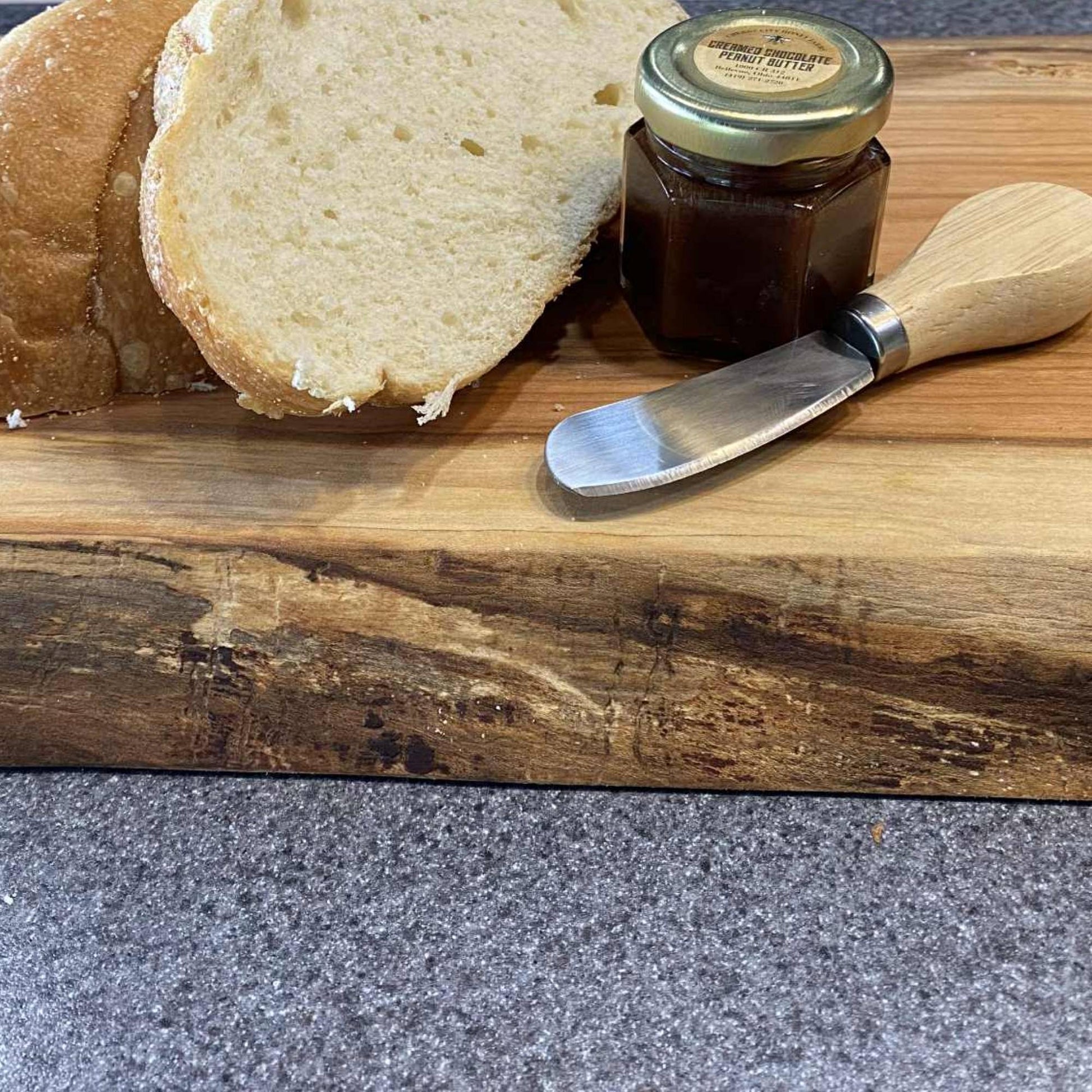 close up of live edge cherry board with bread and honey 