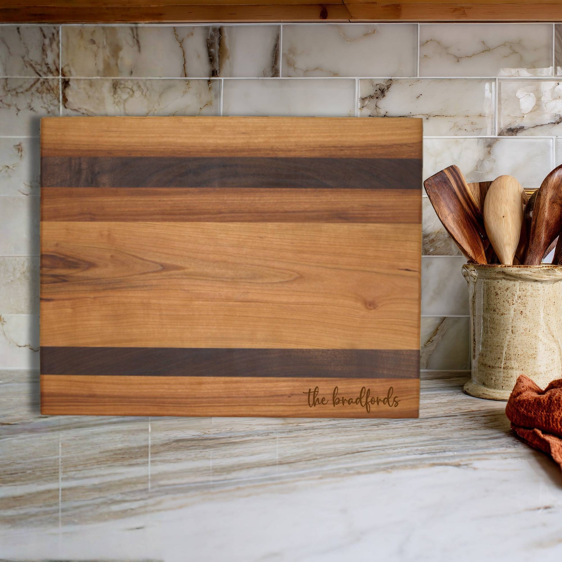cherry and walnut cutting board on kitchen countertop