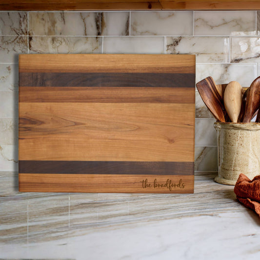 cherry and walnut cutting board on kitchen countertop
