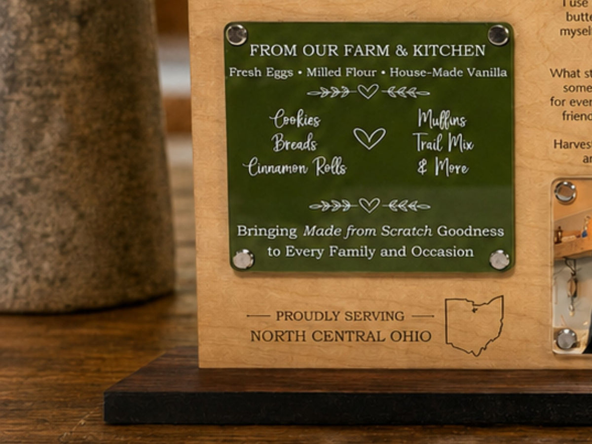 Close-up of a custom maple and acrylic Brand Story Display showing the bakery’s offerings