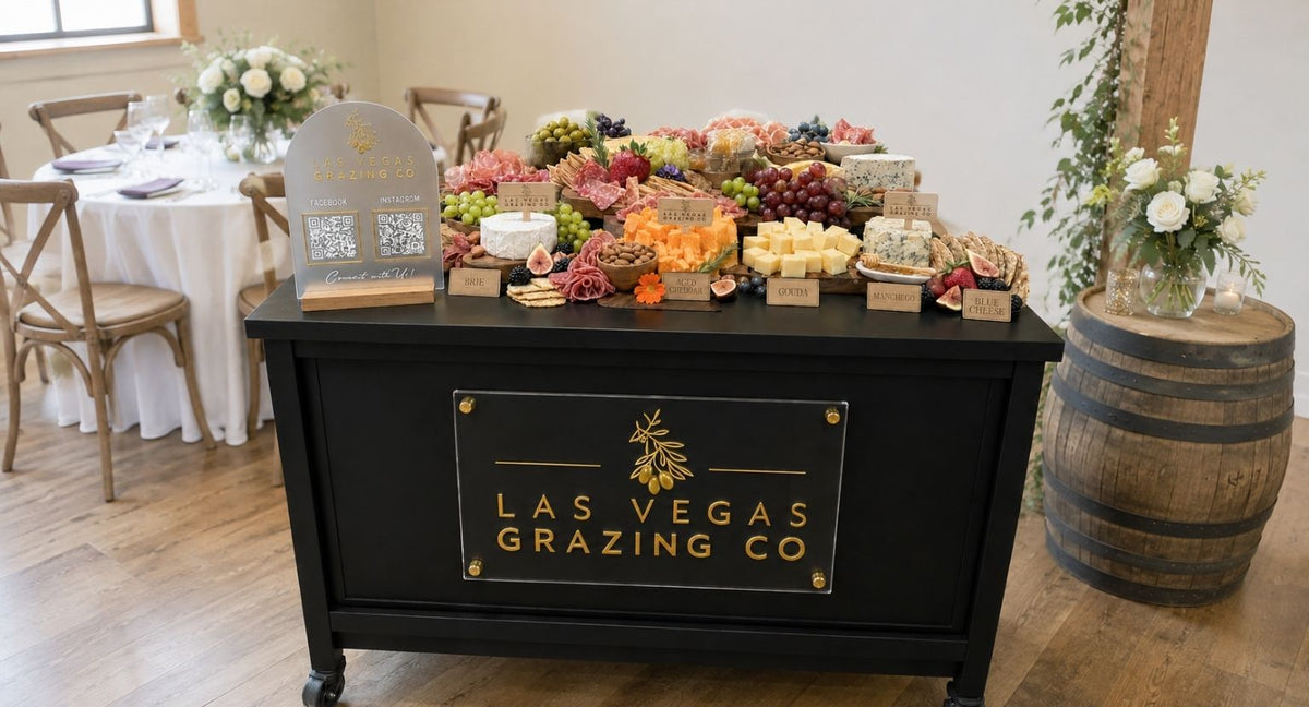 Custom black and gold logo sign displayed on a mobile charcuterie cart
