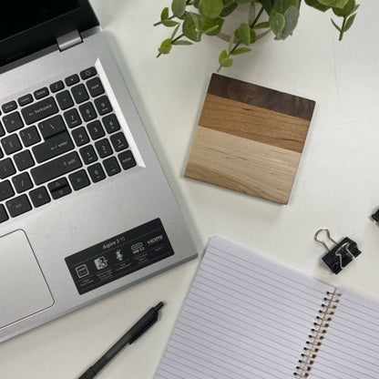 walnut, cherry, and maple handcrafted wood coaster on desk with laptop