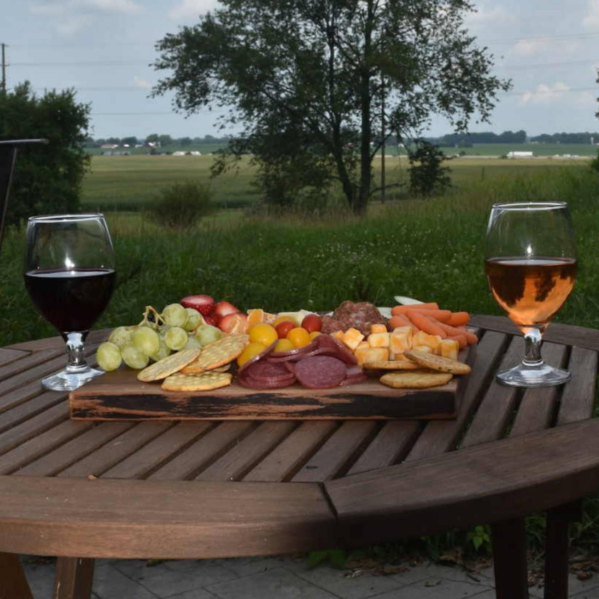 walnut live edge serving board with charcuterie food and wine